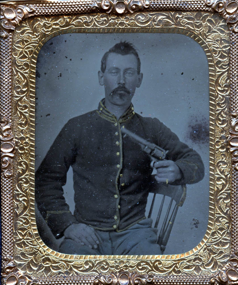 Photograph of James Liddell seated holding a gun.