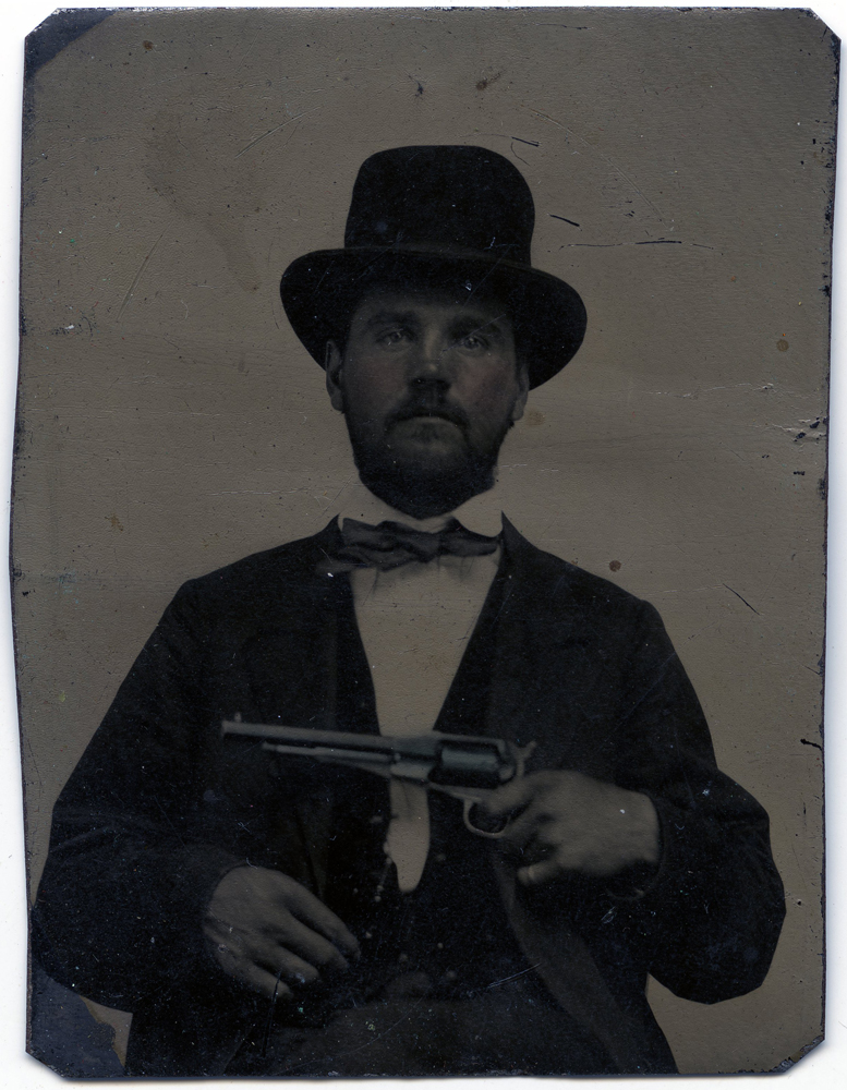 Benjamin Johnson sitting holding revolver.